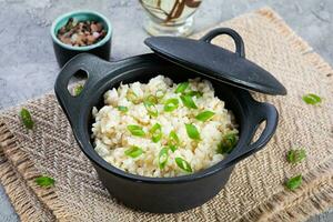 cozido arroz com frango dentro uma Panela em cinzento fundo foto