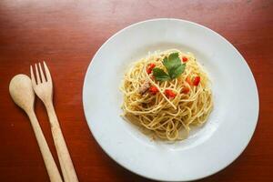 aglio e olio. italiano massa espaguete, aglio olio e calabresa ,espaguete com alhos, Oliva óleo e Pimenta pimentas em prato em mesa foto