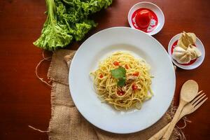 aglio e olio. italiano massa espaguete, aglio olio e calabresa ,espaguete com alhos, Oliva óleo e Pimenta pimentas em prato em mesa foto