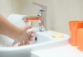 lavando mãos criança lavagem Sabonete com corrida água às Pia foto