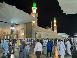 medina, saudita Arábia, pode 2023 - lindo noite Tempo Visão do masjid al nabawi, medina. visitantes, pátios lado de fora a mesquita, lindo luzes e eletrônico guarda-chuvas pode Além disso estar visto. foto