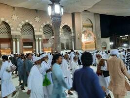 medina, saudita Arábia, pode 2023 - lindo noite Tempo Visão do masjid al nabawi, medina. visitantes, pátios lado de fora a mesquita, lindo luzes e eletrônico guarda-chuvas pode Além disso estar visto. foto