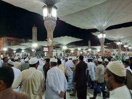 medina, saudita Arábia, pode 2023 - lindo noite Tempo Visão do masjid al nabawi, medina. visitantes, pátios lado de fora a mesquita, lindo luzes e eletrônico guarda-chuvas pode Além disso estar visto. foto