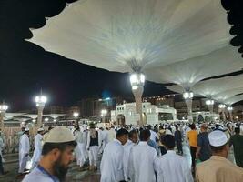 medina, saudita Arábia, pode 2023 - lindo noite Tempo Visão do masjid al nabawi, medina. visitantes, pátios lado de fora a mesquita, lindo luzes e eletrônico guarda-chuvas pode Além disso estar visto. foto