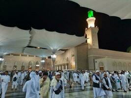 medina, saudita Arábia, pode 2023 - lindo noite Tempo Visão do masjid al nabawi, medina. visitantes, pátios lado de fora a mesquita, lindo luzes e eletrônico guarda-chuvas pode Além disso estar visto. foto