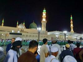 medina, saudita Arábia, pode 2023 - lindo noite Tempo Visão do masjid al nabawi, medina. visitantes, pátios lado de fora a mesquita, lindo luzes e eletrônico guarda-chuvas pode Além disso estar visto. foto