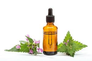 óleo essencial de urtiga isolado no fundo branco óleo de urtiga para aromaterapia de cuidados com a pele e medicina natural foto