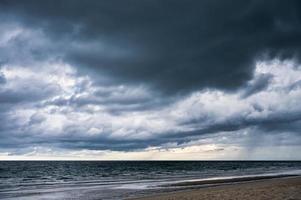 céu escuro dramático e nuvens tempestuosas sobre o mar foto