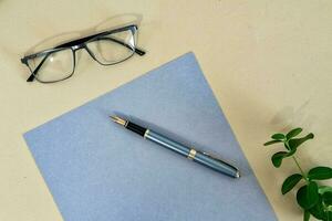 o negócio conceito. papel rústico folha, caneta e Óculos em bege fundo. foto