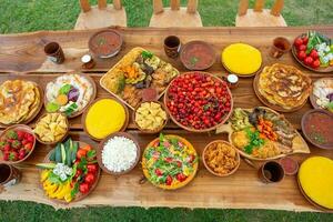 caseiro romena Comida com grelhado carne, polenta e legumes prato em acampamento. romântico tradicional moldaviano Comida lado de fora em a madeira mesa. foto