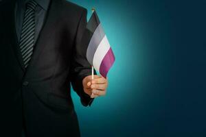 homem de negocios mão segurando bandeira dentro assexual orgulho cores. foto