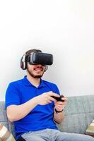 fechar-se do barbudo jovem homem vestindo virtual realidade óculos às lar. foto