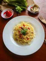 aglio e olio. italiano massa espaguete, aglio olio e calabresa ,espaguete com alhos, Oliva óleo e Pimenta pimentas em prato em mesa foto