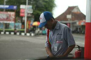 Magelang central Java, Indonésia - Junho 30, 2023-a masculino gás estação atendente é reabastecimento. foto