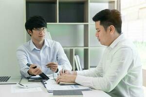 homem de negocios explicando para colegas uma gráfico do financeiro despesas figuras dentro uma tábua. foto