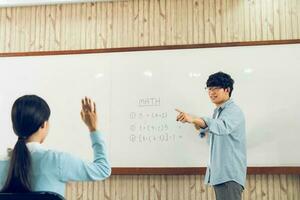 professor masculino asiático ensinando alunos na sala de aula foto