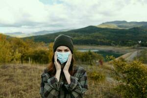 lindo mulher detém uma médico mascarar em dela face em natureza dentro a floresta foto