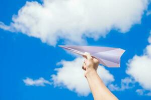 papel avião em mão com céu e clound fundo foto