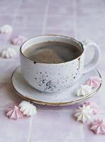 xícara com café e pequenos merengues