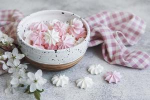 pequenos merengues brancos e rosa na tigela de cerâmica foto