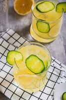 desintoxicação verão limonada com limão e pepino dentro óculos em a mesa vertical Visão foto