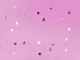 Estrelas e árvores de confete cintilando em fundo rosa foto