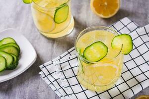 desintoxicação verão limonada com limão e pepino dentro óculos em a mesa foto