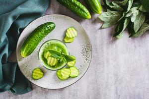 refrescante pepino e hortelã batido dentro uma vidro em a mesa topo Visão foto