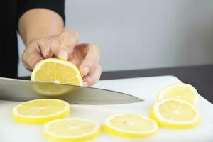 chefe de cozinha é fatiamento limão em cozinha borda foto