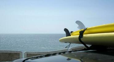 pranchas de surf carregado para uma carro perto a costa do ericeira, Portugal foto
