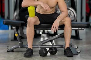 homem desportivo treinando com halteres na academia fisiculturista esporte fitness training foto
