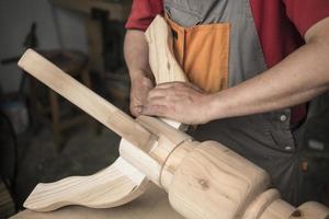 carpinteiro faz mesa com pernas entalhadas foto