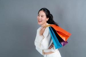 mulher asiática segurando sacolas de compras foto