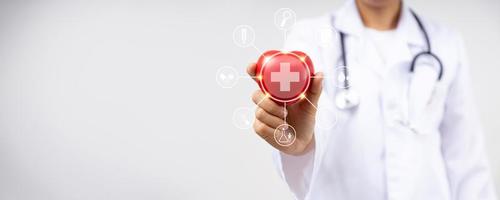 feche a mão de um médico segurando um coração vermelho por causa de doenças cardíacas, conceito de serviço de seguro saúde