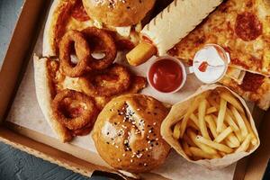 comida insalubre e lixo. diferentes tipos de fast food na mesa, closeup foto