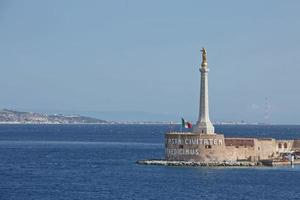 vista do porto de messinas com a estátua de ouro de madonna della lettera na sicília, itália