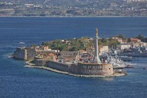 vista do porto de messinas com a estátua de ouro de madonna della lettera na sicília, itália