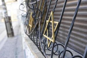 uma cerca de metal com uma estrela judia dourada foto