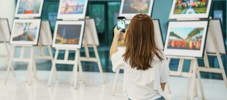 jovem fêmea turista olhando galeria exibição. arte , fotografia e museu conceito foto