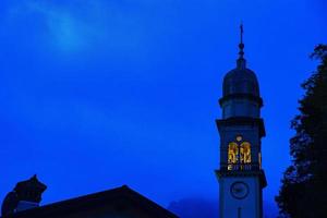 céu azul noturno com torre sineira foto