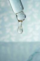 uma gotejamento pipeta com uma solta do cosméticos gel. foto