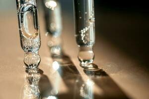 três pipetas do Cosmético gel em uma bege fundo. foto