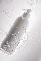 uma garrafa do chuveiro gel, xampu ou corpo creme em a fundo do gotas. foto