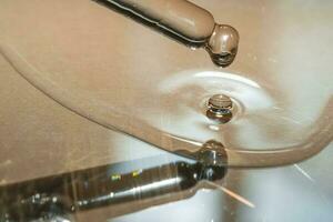 uma gotejamento pipeta do Cosmético gel em uma bege fundo. foto
