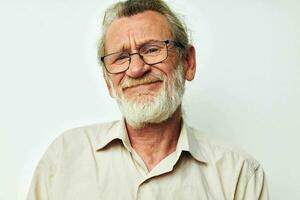 retrato do feliz Senior homem com uma cinzento barba dentro uma camisa e óculos isolado fundo foto