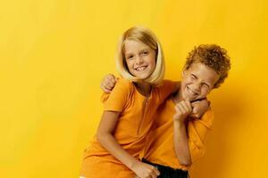 fofa pré escola crianças casual vestem jogos Diversão juntos posando em colori fundo foto