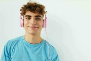 atraente homem dentro azul Camisetas Rosa fones de ouvido moda estilo de vida inalterado foto