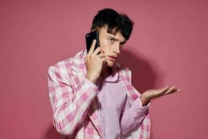 bonita homem com uma telefone dentro mão Rosa blazer moda elegante estilo isolado fundo inalterado foto