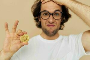 alegre homem dentro uma branco camiseta com bitcoin criptomoeda bege fundo foto