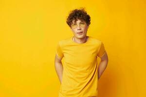 jovem cabelo encaracolado homem vestindo à moda óculos amarelo camiseta posando monocromático tiro foto